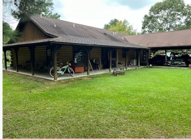 back of property with log siding, a yard, and a patio area