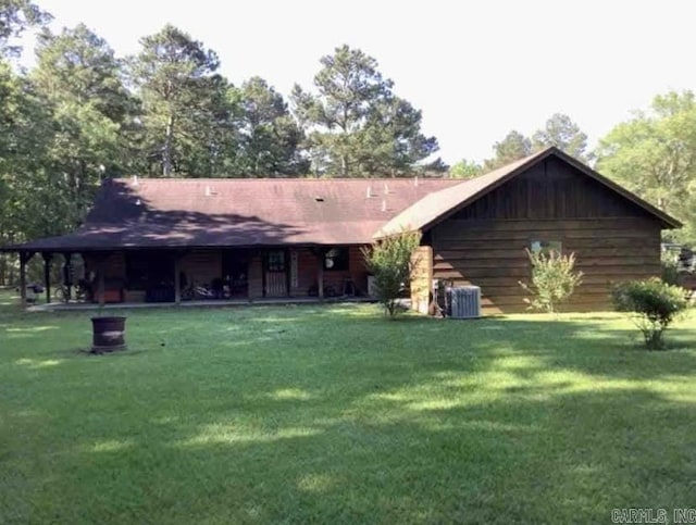 rear view of property featuring a lawn and central AC