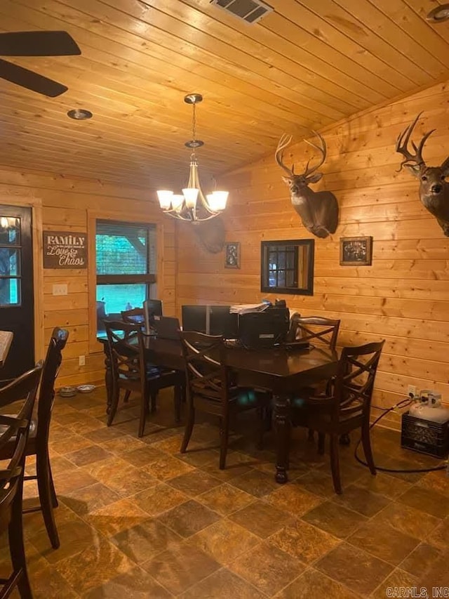 dining area featuring visible vents, wooden walls, wood ceiling, and a notable chandelier