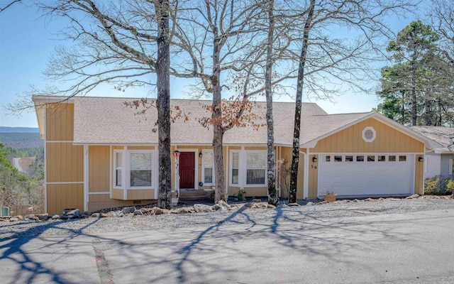 view of front of home featuring an attached garage and roof with shingles