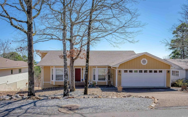 ranch-style home featuring an attached garage, roof with shingles, and driveway