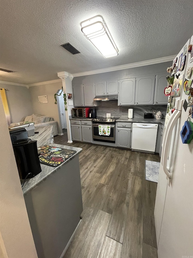 kitchen featuring white appliances, gray cabinetry, dark wood-type flooring, under cabinet range hood, and crown molding