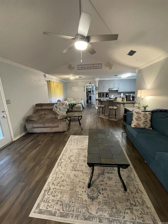 living area featuring baseboards, dark wood-style flooring, ceiling fan, vaulted ceiling, and crown molding