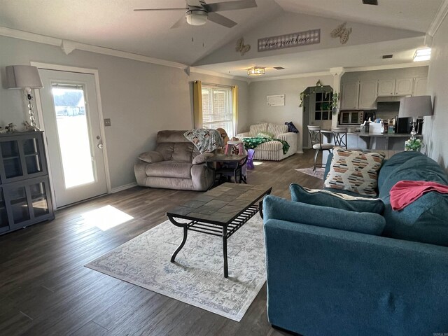 living area with dark wood finished floors, a ceiling fan, lofted ceiling, and ornamental molding