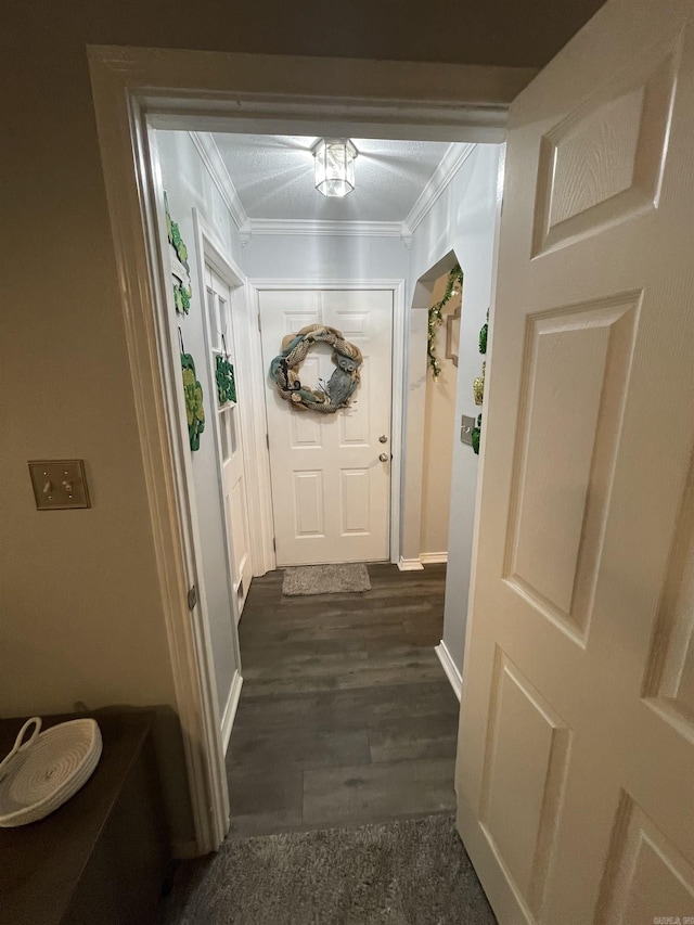 entryway with baseboards, dark wood-type flooring, and ornamental molding