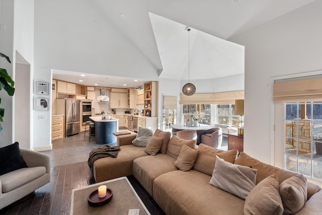 living room featuring light wood finished floors, recessed lighting, and high vaulted ceiling