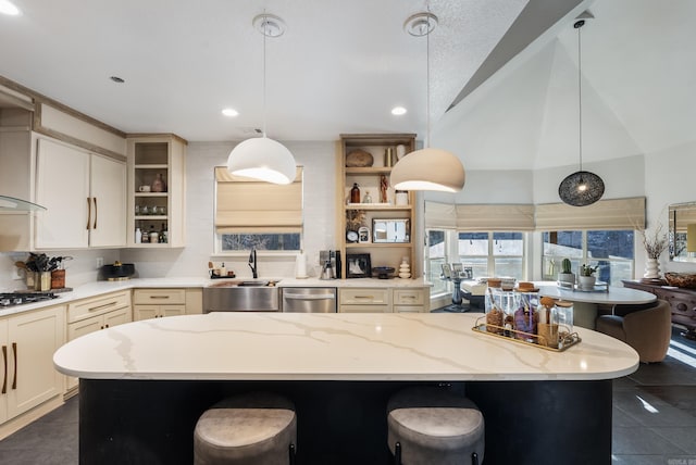 kitchen featuring gas cooktop, open shelves, a sink, dishwasher, and dark tile patterned floors