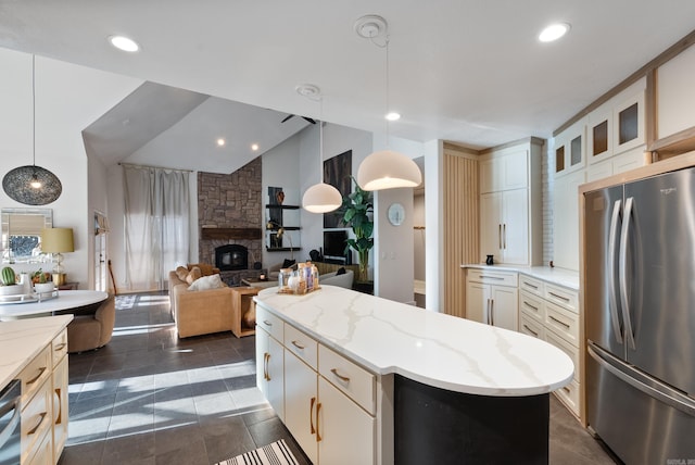 kitchen with a kitchen island, lofted ceiling, a fireplace, stainless steel appliances, and glass insert cabinets