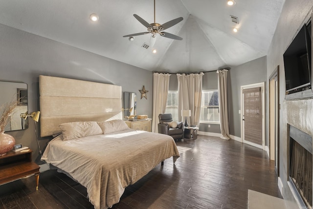 bedroom featuring a premium fireplace, visible vents, baseboards, and wood finished floors