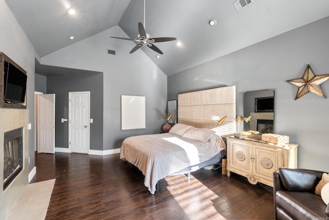 bedroom with wood finished floors, baseboards, visible vents, high vaulted ceiling, and a fireplace with flush hearth