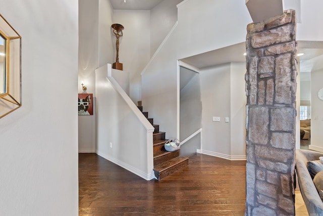 foyer featuring stairway, a high ceiling, wood finished floors, and baseboards