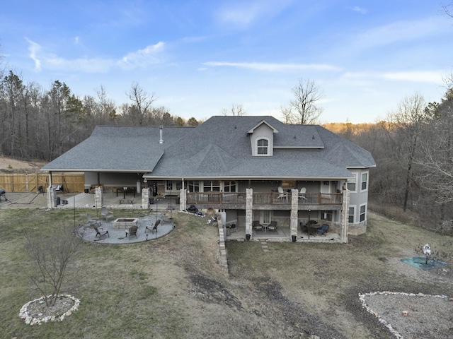 back of house featuring a patio area, roof with shingles, and an outdoor fire pit