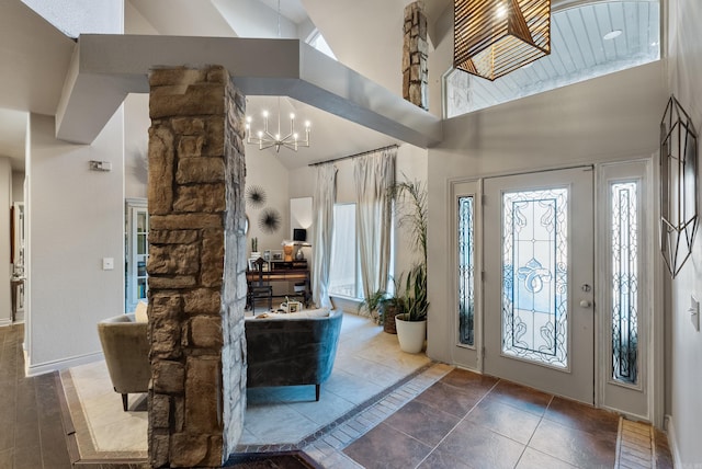 tiled foyer featuring an inviting chandelier and high vaulted ceiling