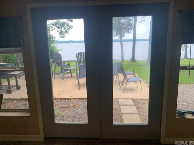 doorway to outside with french doors, a water view, and a healthy amount of sunlight