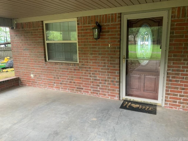 property entrance featuring brick siding