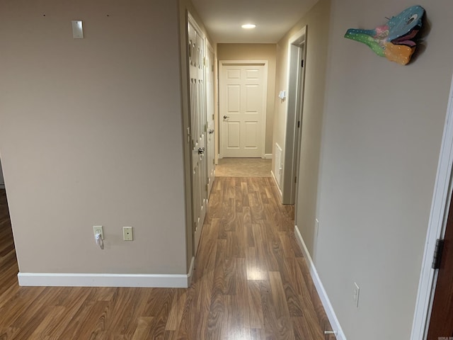 hallway with baseboards and wood finished floors