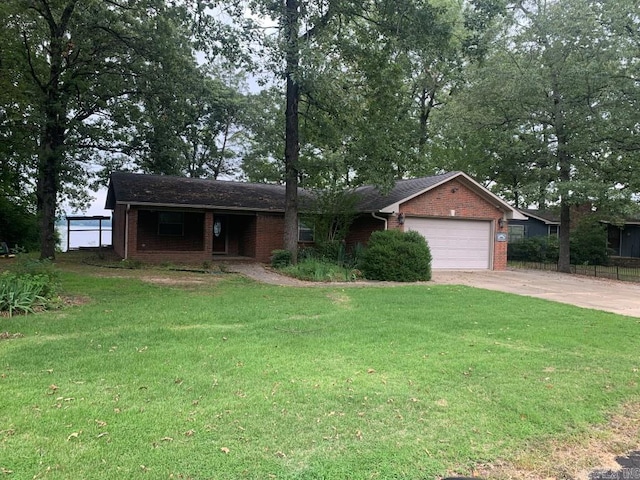 ranch-style home featuring brick siding, an attached garage, concrete driveway, and a front yard