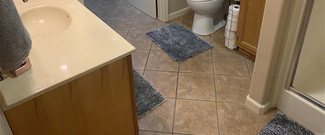 bathroom featuring toilet, vanity, and tile patterned flooring