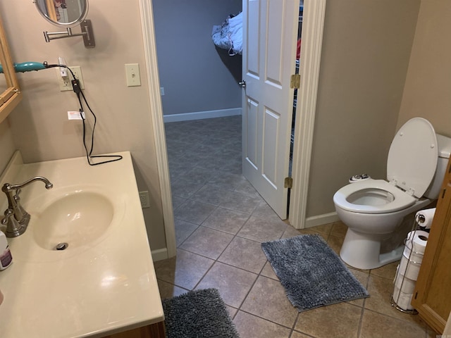 bathroom with tile patterned floors, baseboards, toilet, and vanity