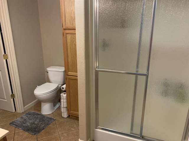 full bath featuring tile patterned flooring, toilet, and a stall shower