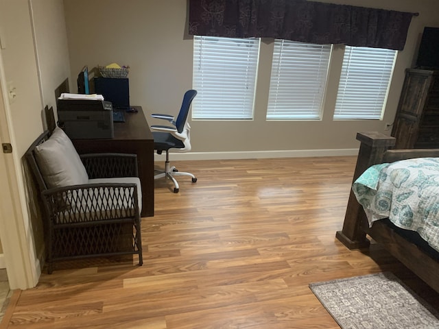 bedroom with baseboards and wood finished floors