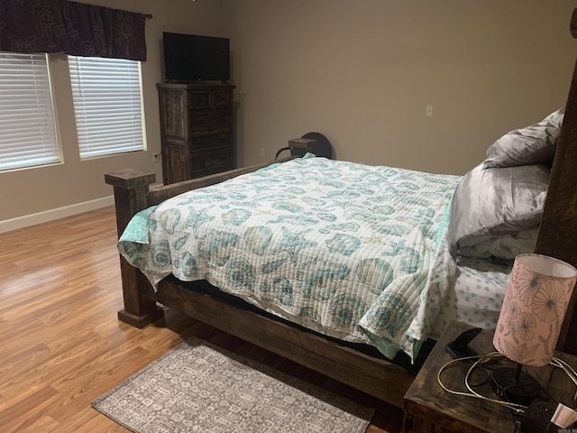 bedroom with baseboards and wood finished floors