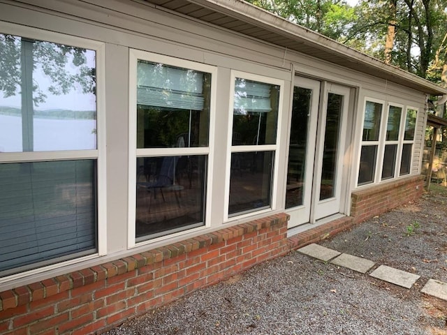 view of side of home featuring a water view and brick siding