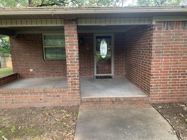 entrance to property featuring brick siding