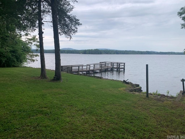 view of dock featuring a water view and a lawn