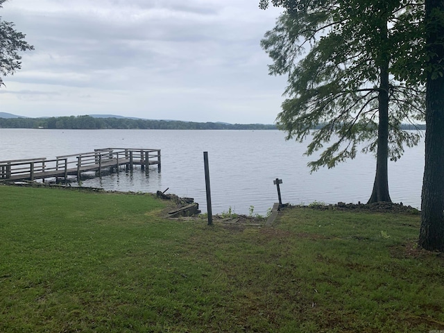 dock area with a lawn and a water view