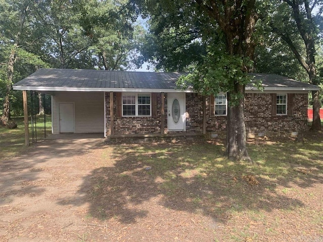 single story home featuring a carport, dirt driveway, metal roof, crawl space, and brick siding