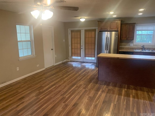 kitchen with baseboards, french doors, freestanding refrigerator, dark wood-style floors, and a sink