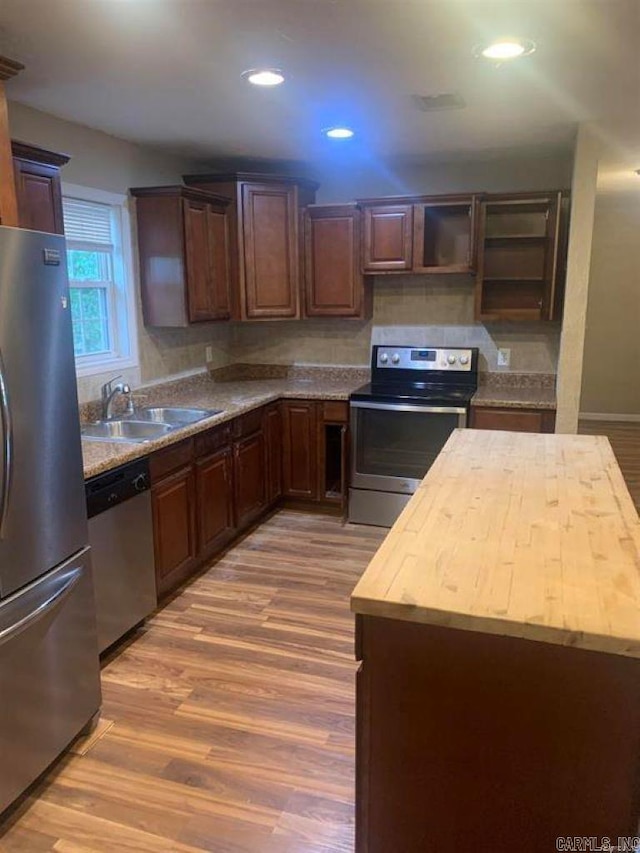 kitchen featuring light wood-style flooring, recessed lighting, appliances with stainless steel finishes, and a sink