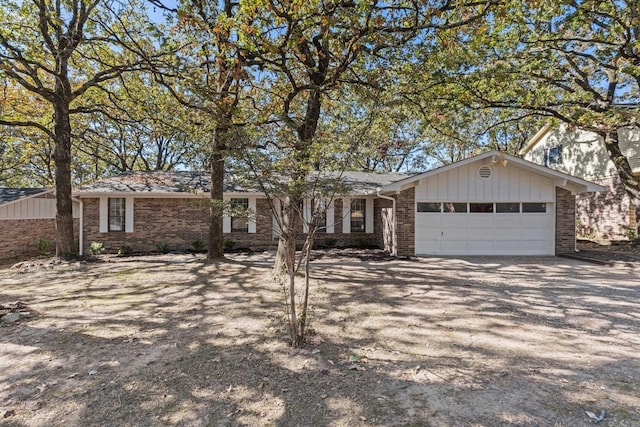 single story home with brick siding, driveway, and a garage