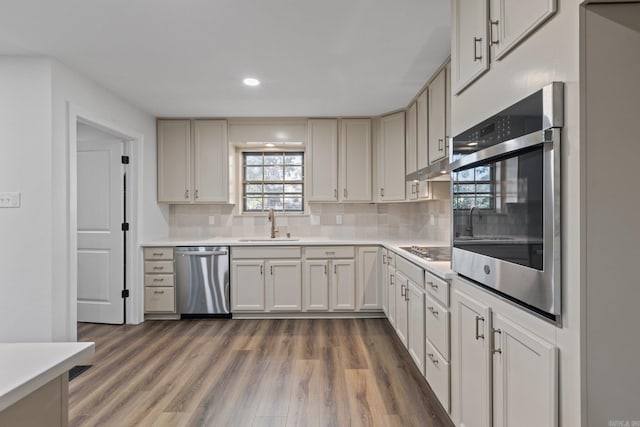 kitchen with dark wood finished floors, recessed lighting, light countertops, appliances with stainless steel finishes, and tasteful backsplash