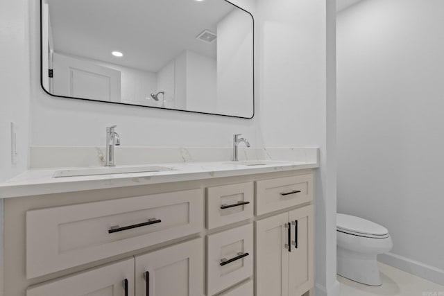 full bath with double vanity, visible vents, toilet, and a sink