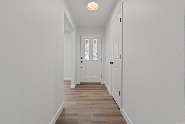 doorway to outside with wood finished floors and baseboards