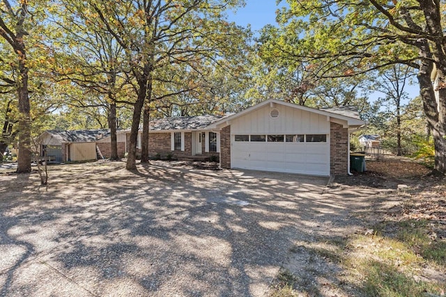 view of front facade with a garage, brick siding, and driveway