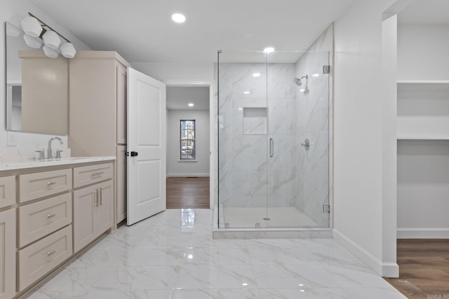 full bathroom with a marble finish shower, baseboards, marble finish floor, and vanity