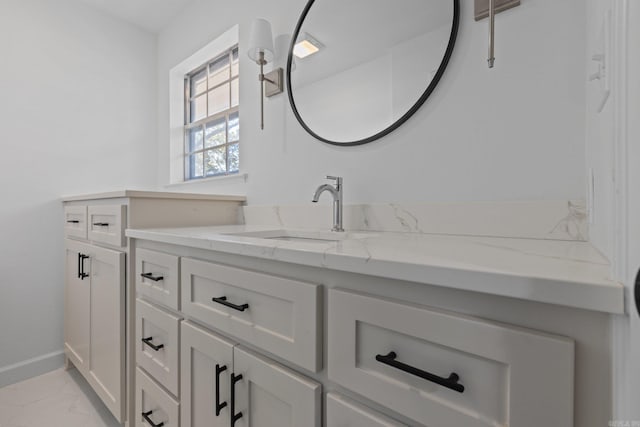 bathroom with baseboards, marble finish floor, and vanity