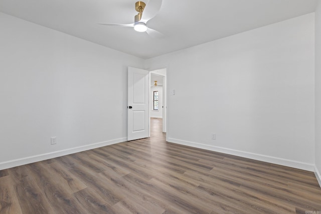 empty room with ceiling fan, baseboards, and wood finished floors