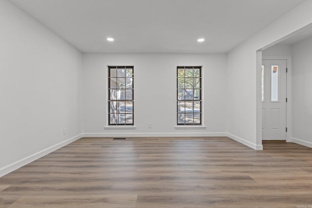 unfurnished room featuring visible vents, recessed lighting, baseboards, and wood finished floors