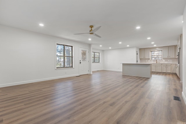 unfurnished living room featuring plenty of natural light, wood finished floors, recessed lighting, and ceiling fan