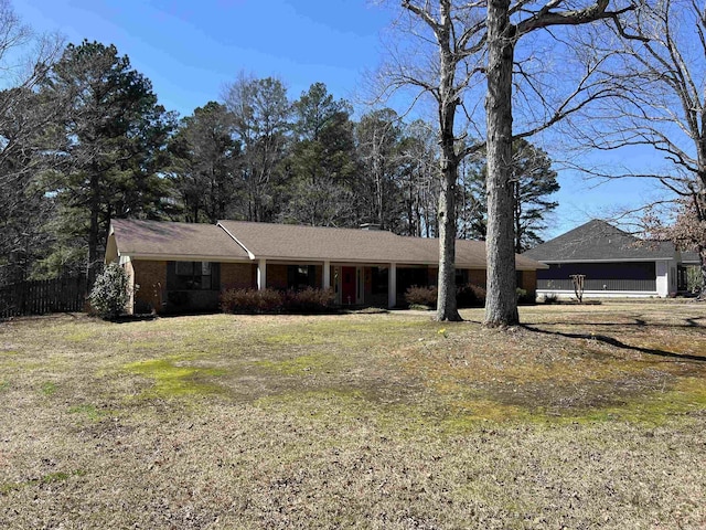 ranch-style home featuring a front yard and fence