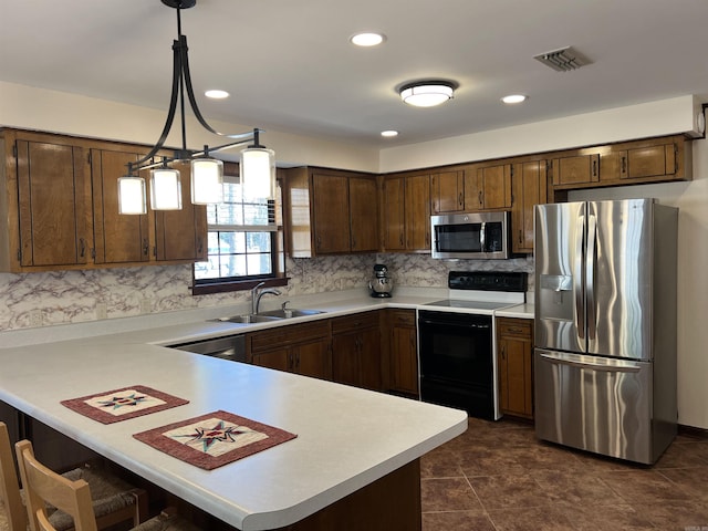 kitchen featuring visible vents, a peninsula, a sink, stainless steel appliances, and light countertops