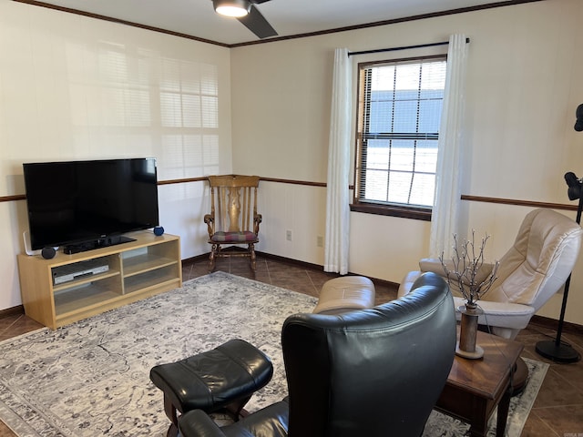 living room featuring ceiling fan, tile patterned floors, baseboards, and ornamental molding