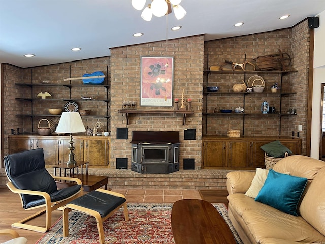 living room featuring recessed lighting, brick wall, and a wood stove