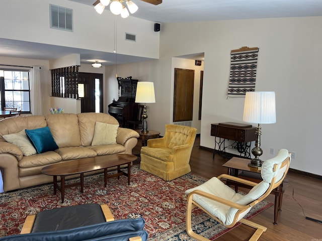 living room with a ceiling fan, wood finished floors, visible vents, and baseboards