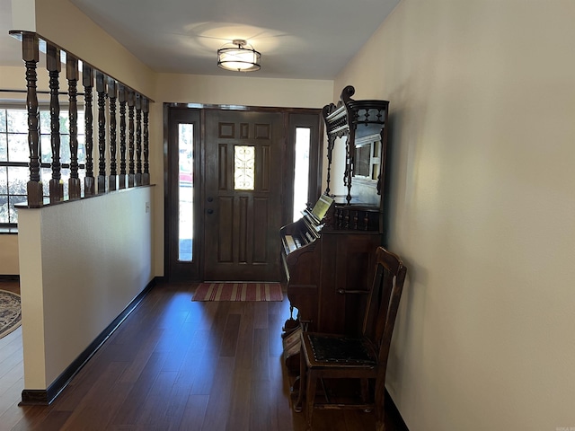 entrance foyer with dark wood-style floors and baseboards