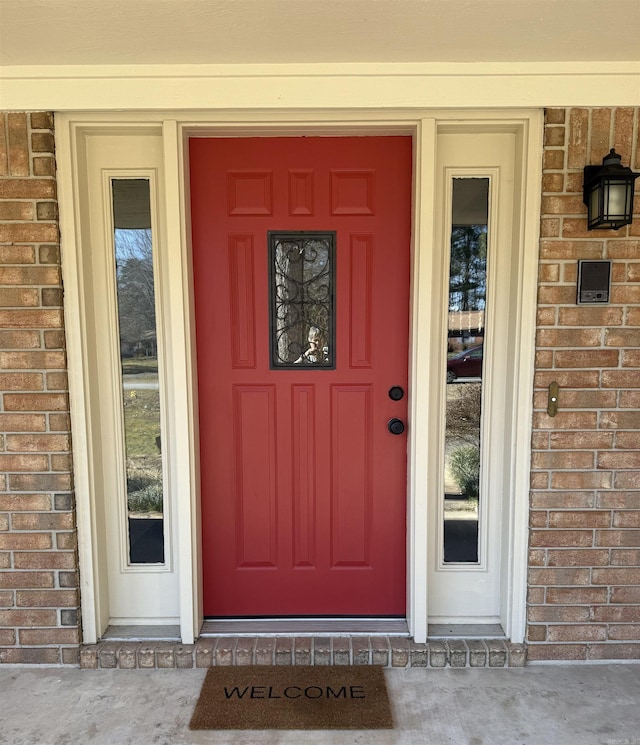 view of exterior entry featuring brick siding